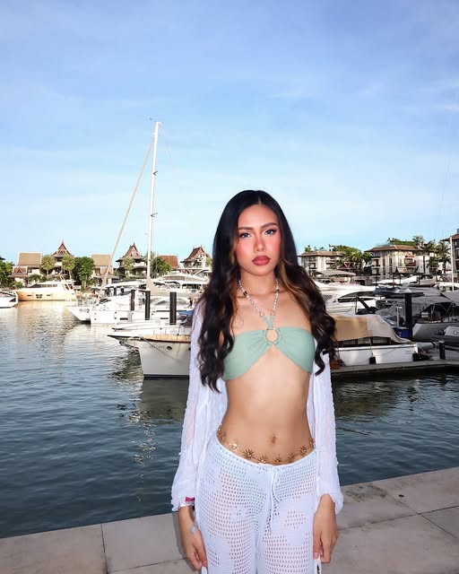 Kaybe at a marina with yachts behind her